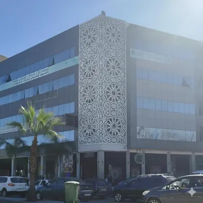 a building with a white facade with cars parked in a parking lot at PAUSE HOUSE-Downtown-Front of Station-Airport Bus-FREE COUSCOUS Friday in Fès
