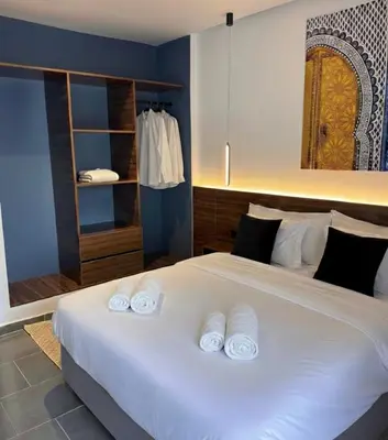 a bedroom with a large white bed with three pillows at PAUSE HOUSE-Downtown-Front of Station-Airport Bus-FREE COUSCOUS Friday in Fès