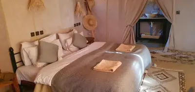 a bedroom with a large bed with two towels on it at Itran desert camp in Merzouga