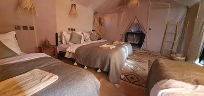 a bedroom with two beds in a room at Itran desert camp in Merzouga