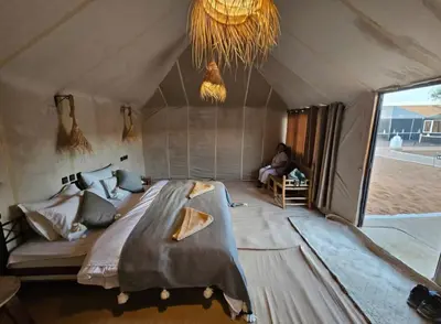 a bedroom with a large bed in a tent at Itran desert camp in Merzouga