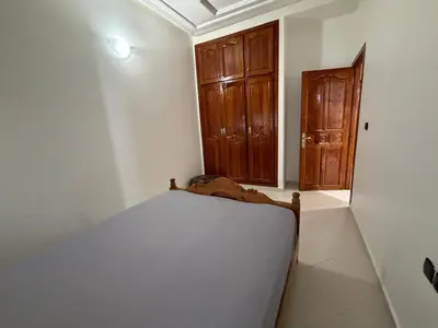 a bedroom with a bed and a wooden door at Apartment in downtown Fez in Fès