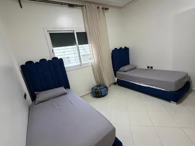 a bedroom with two beds and a window at Apartment in downtown Fez in Fès