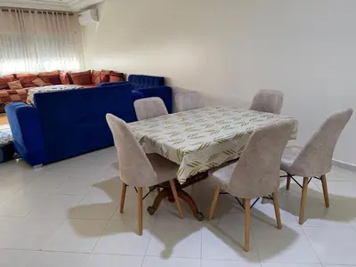 a dining room table with chairs and a blue couch at Apartment in downtown Fez in Fès
