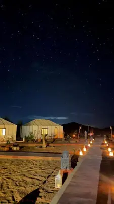 a row of lights on a sidewalk at night at Bivouac luxury camp in Merzouga