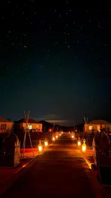 a long row of lights on a street at night at Bivouac luxury camp in Merzouga