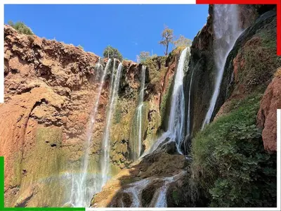 a waterfall on the side of a cliff at Central apartment for families near the waterfall in Azilal