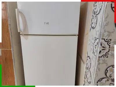 a white refrigerator in a kitchen next to a curtain at Central apartment for families near the waterfall in Azilal