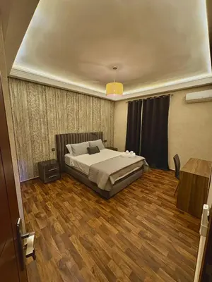 a bedroom with a bed and a wooden floor at Oasis Suite in Fès