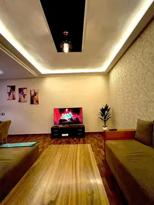 a living room with a flat screen tv on the wall at Oasis Suite in Fès