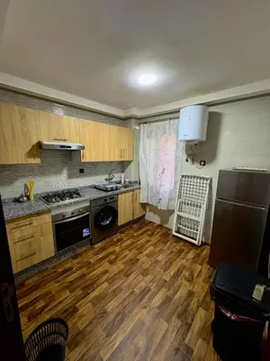 a kitchen with wooden floors and a sink and a refrigerator at Oasis Suite in Fès
