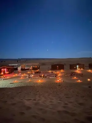 a group of lodges in the desert at night at Desert Family Camp in El Gouera