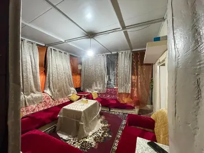 a living room with a red couch and a table at Dar charfa in Fès