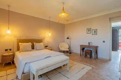 a bedroom with a large bed and a table at Villa Chocolat in Marrakech