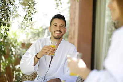 a man in a robe holding a glass of wine at Villa Chocolat in Marrakech