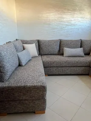 a couch with two pillows on it in a room at Appartement Diyar Saiss in Meknès