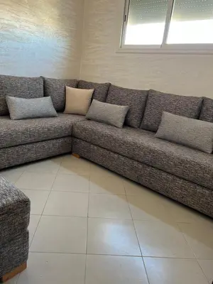 a couch in a living room with pillows on it at Appartement Diyar Saiss in Meknès
