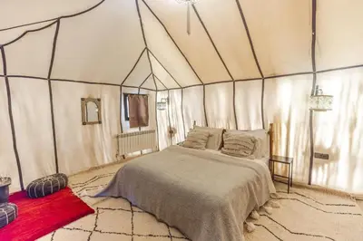 a bedroom with a bed in a tent at Azalai Haven Camp in Merzouga