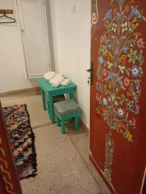 a room with a table and a bench next to a door at dar andalosse fes in Fès