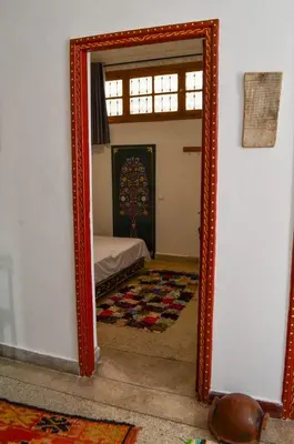 a mirror reflecting a bedroom with a bed in a room at dar andalosse fes in Fès