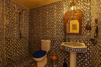 a blue and white bathroom with a sink and a toilet at Riad jnan lward in Fès