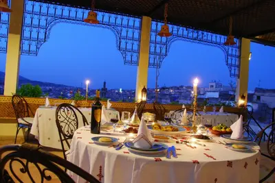 a table with plates of food on it with a view at EL Ghalia in Fès