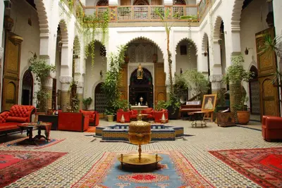 a large lobby with red chairs and a table at EL Ghalia in Fès