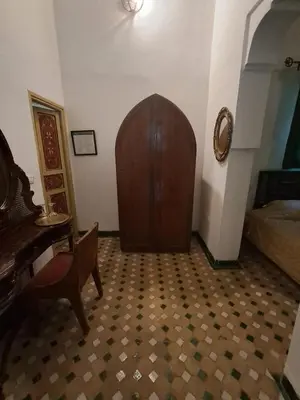 a room with a desk and a dresser and a bedroom at EL Ghalia in Fès