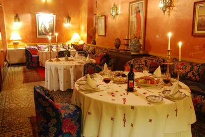 a dining room with two tables with white table cloths at EL Ghalia in Fès