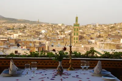 a table with wine glasses and a view of a city at EL Ghalia in Fès