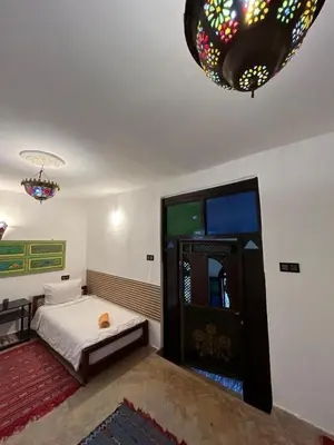 a room with a bed and a chandelier at Riad Sahara sol in Fès