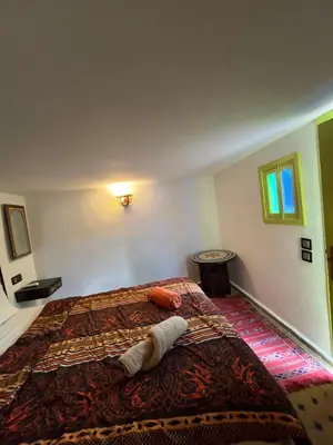 a bedroom with a large bed with a blanket on it at Riad Sahara sol in Fès