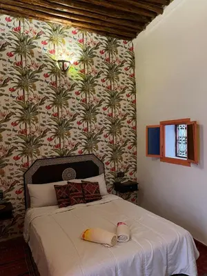 a bedroom with a large bed with a wall at Riad Sahara sol in Fès