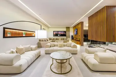 a living room with white couches and a table at Hidaya Villa - Heated Pool, Padel , Spa & Gym in Najem