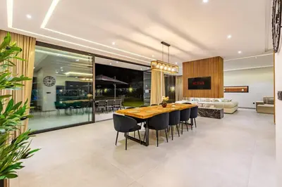 a dining room and living room with a table and chairs at Hidaya Villa - Heated Pool, Padel , Spa & Gym in Najem