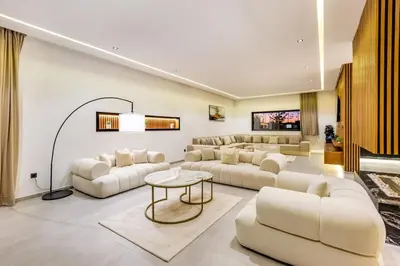 a living room with white couches and a table at Hidaya Villa - Heated Pool, Padel , Spa & Gym in Najem