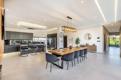 a kitchen and dining room with a wooden table and chairs at Hidaya Villa - Heated Pool, Padel , Spa & Gym in Najem