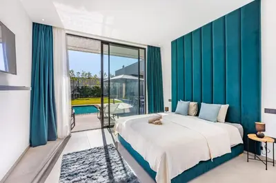 a bedroom with a large bed with blue walls at Hidaya Villa - Heated Pool, Padel , Spa & Gym in Najem