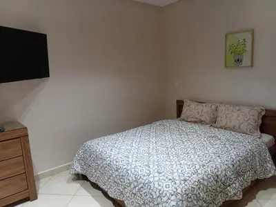 a bedroom with a bed and a flat screen tv at Annakhil 30 in Oulad Akkou