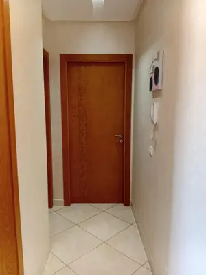 a hallway with a brown door and a tile floor at Annakhil 30 in Oulad Akkou