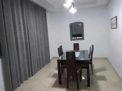 a dining room with a table and chairs and a tv at Touahri C TW01 Apartment - Centre in Oulad Akkou