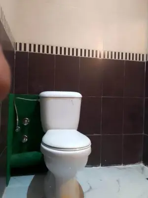 a bathroom with a white toilet and a green towel at Touahri C TW01 Apartment - Centre in Oulad Akkou