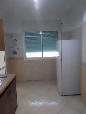 a kitchen with a refrigerator and a window at Touahri C TW01 Apartment - Centre in Oulad Akkou