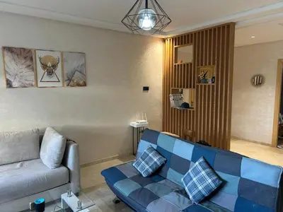 a living room with a blue couch in a room at Beach-front paradise with parking and pool in Oulad Akkou
