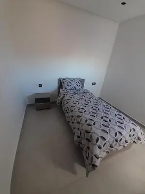 a bedroom with a bed in a white room at Al Anouar B40 in Oulad Akkou