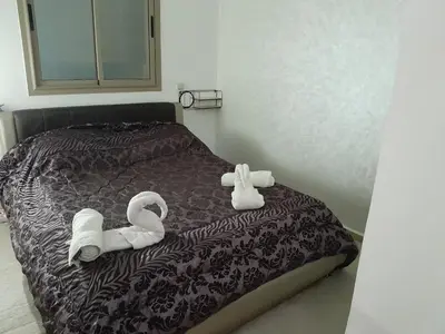 a bed with two swans and towels on it at Serene City Escape in Meknès
