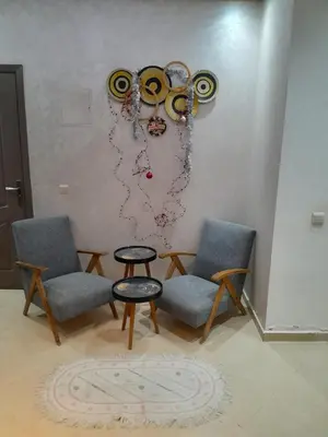 a room with two chairs and a table and a wall at Serene City Escape in Meknès