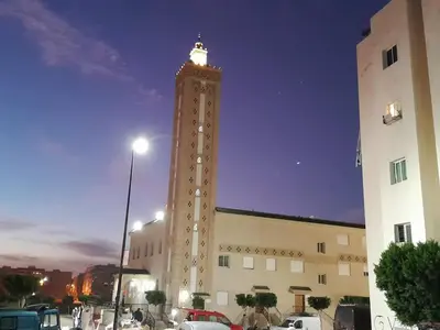 a tall tower with a clock on top of a building at Serene City Escape in Meknès