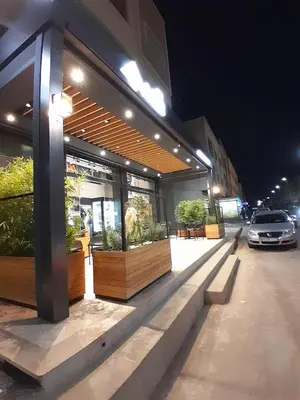 a store front with plants on a street at night at Serene City Escape in Meknès