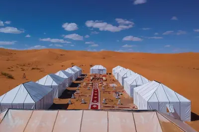 a group of white tents in the desert at merzouga asamer in Merzouga